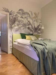 1 dormitorio con 1 cama con un mural de plantas en Green flat by GrazRentals with garden view & parking included en Graz