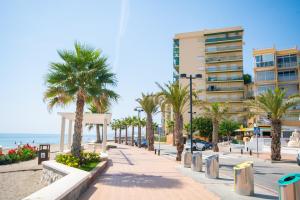 a beach with palm trees and a building at Cubo's Apartamento 2 Concha del Mar in Fuengirola