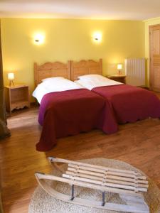 Un dormitorio con una cama grande y un banco en Auberge du Couvige, en Le Bouchet-Saint-Nicolas