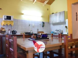 a kitchen with a wooden table with chairs and a kitchen at Casa Elcrismar in Lago Puelo