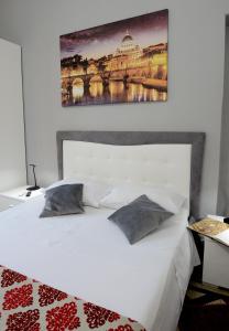 羅馬的住宿－Casa Dania，卧室配有一张白色床,墙上挂有绘画作品
