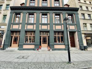 a large building with people sitting in front of it at Apartamenty Nova 22 in Toruń