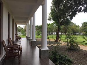 een veranda van een huis met stoelen en zuilen bij Goddess Garden Sigiriya in Sigiriya