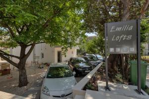 una señal frente a un estacionamiento con coches en Emilia Lofts, en Tučepi