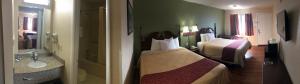 a hotel room with two beds and a bathroom at Motor Inns Of America in Madisonville