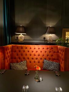 an orange couch in a restaurant with a table at Apartamenty Nova 22 in Toruń
