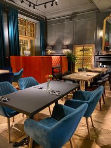 a dining room with tables and blue chairs at Apartamenty Nova 22 in Toruń