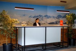 uma mulher parada num balcão num escritório em Atrium Exclusive - Ski4Life em Gudauri mais 72 fotografias