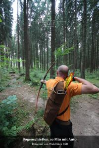 
a man holding a stick in his hand while standing in the woods at Hotel Waldblick in Donaueschingen
