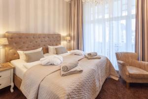 1 dormitorio con 1 cama grande y toallas. en Hotel Vier Jahreszeiten Binz - Adults Only en Binz