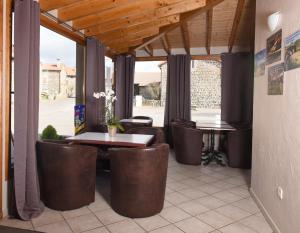 un patio con mesa, sillas y mesa en Auberge du Couvige, en Le Bouchet-Saint-Nicolas