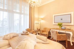 a hotel room with a bed and a desk and a room at Hotel Vier Jahreszeiten Binz in Binz