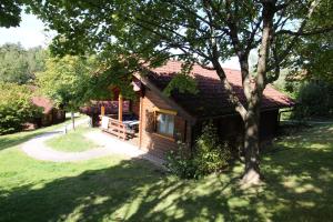 una cabaña de madera con un árbol en un patio en Romantikhütten 1 & 24, en Stamsried