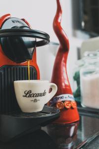 拿坡里的住宿－Terno su Napoli，咖啡壶把咖啡倒在柜台的杯子里
