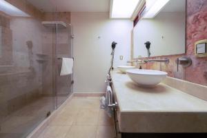 a bathroom with two sinks and a glass shower at Penthouse Reef 401 - Beautiful Beachfront Ocean View - at El Faro in Playa del Carmen