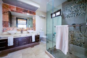 a bathroom with two sinks and a glass shower at Penthouse Reef 401 - Beautiful Beachfront Ocean View - at El Faro in Playa del Carmen