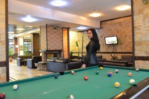 a woman standing next to a pool table at Royal Bansko Family Apart Hotel - All Inclusive Light or Half Board & Drinks With Heated Indoor Pool & Jacuzzis in Bansko