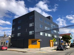 un edificio negro y amarillo en una calle de la ciudad en Patagonia Apart Hotel - Suite, en Punta Arenas