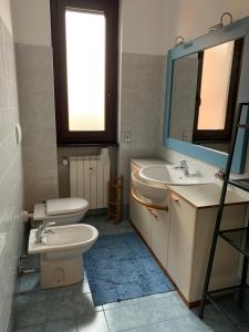 a bathroom with a sink and a toilet and a mirror at Casa Vacanza Nadia in Bergamo