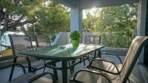a table and chairs on a balcony with a plant at Enalia Luxury Living in Nikiti