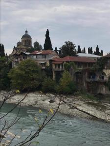 a building on a hill next to a river at ART HOUSE 33 in Kutaisi