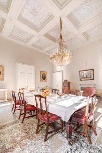 a dining room with a table with chairs and a chandelier at Palazzo D'Oltrarno - Residenza D'Epoca in Florence