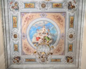 a painting on a ceiling with a chandelier at Palazzo D'Oltrarno - Residenza D'Epoca in Florence