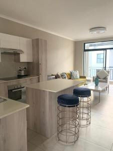 a kitchen with two bar stools and a counter at Canvas Luxury Apartments in Johannesburg