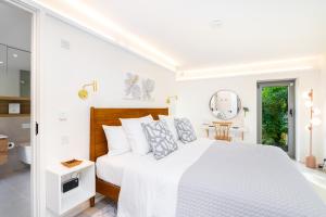 a white bedroom with a large bed and a mirror at The Barn : Luxury Indoor/Outdoor Countryside Bliss in Clipston