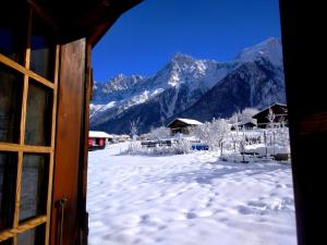 Blick auf einen schneebedeckten Berg aus dem Fenster in der Unterkunft Chalet Le Marmouzet in Les Houches
