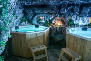 eine Whirlpool-Badewanne in einer Höhle mit Kamin in der Unterkunft Gorgeous Villa in Cluj-Napoca