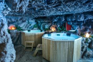 a spa room with two hot tubs in a cave at Gorgeous Villa in Cluj-Napoca