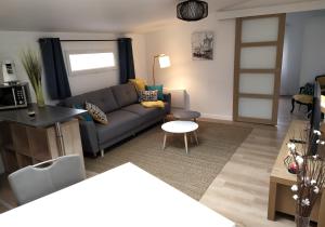 - un salon avec un canapé et une table dans l'établissement La perle du 58 - T2 Parking Wifi Terrasse CLIM, à Rodez