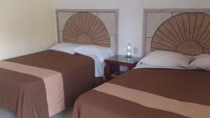 a hotel room with two beds and a table at Hotel Albatros Palace in Manzanillo