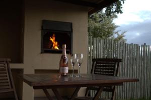 uma garrafa de vinho sentada numa mesa com dois copos de vinho em Wild Clover Cottages em Stellenbosch