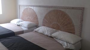 two beds sitting next to each other in a room at Hotel Albatros Palace in Manzanillo