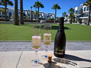 - une bouteille de vin et deux verres sur une table dans l'établissement Oasis Beach X 106, à Guardamar del Segura