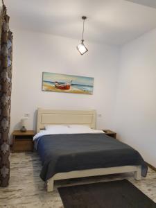 a bedroom with a bed with a painting on the wall at Han Dunarea in Călăraşi