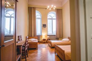 a hotel room with two beds and a table and chairs at Villa Kaunensis in Kaunas