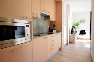 a kitchen with white cabinets and a microwave at Lux Renard "Acceso directo a pistas" in Pas de la Casa