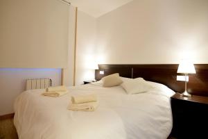 a bedroom with a white bed with two towels on it at Lux Renard "Acceso directo a pistas" in Pas de la Casa