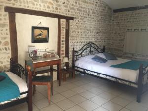 1 dormitorio con 2 camas, mesa y escritorio en Le Moulin de Champagne en Viriat