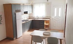 Una cocina con una mesa y un refrigerador blanco. en La Bonanza, en Timijiraque