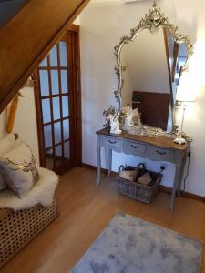 a dressing table with a mirror in a room at Fab-u-Luss in Luss