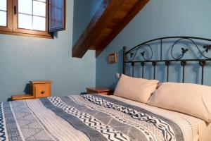 a bedroom with a bed with a blue wall at Apartamentos Carmen de Castro in Comillas