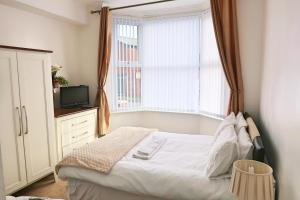 a small bedroom with a bed and a window at Whitburn Guest House About 7 mins Walk To The City Free Internet TV in Doncaster
