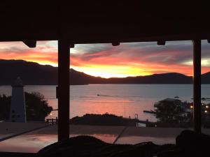 a sunset viewed from a bedroom window with a lighthouse at Lighthouse Townhouse in Valle de Bravo