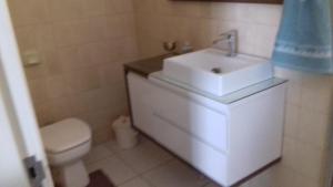 ein Badezimmer mit einem weißen Waschbecken und einer Toilette in der Unterkunft Casa 183 in Itajaí + 26 Fotos