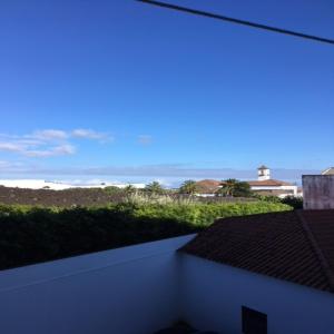 - une vue sur la plage depuis le balcon d'une maison dans l'établissement LEVADA APARTMENT, à Ponta Delgada