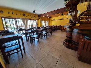 a restaurant with wooden tables and chairs and yellow walls at Hotel Vireo in Villa Gesell